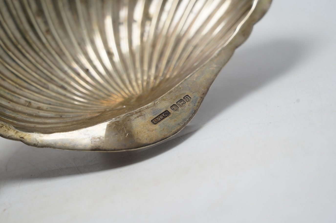 A George VI silver shell dish, Sheffield, 1946, 14.2cm, a modern silver mounted wine coaster and a late Victorian silver five bar toast rack. Condition - fair